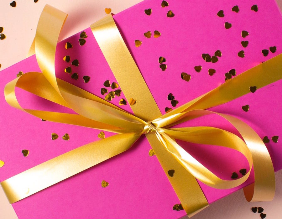Present with pink gift wrap and gold bow