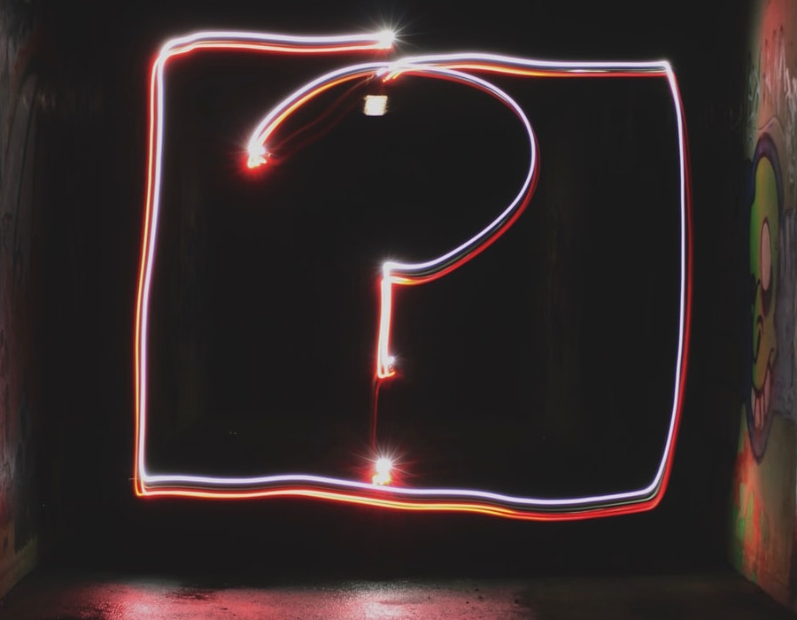 Neon question mark on black background
