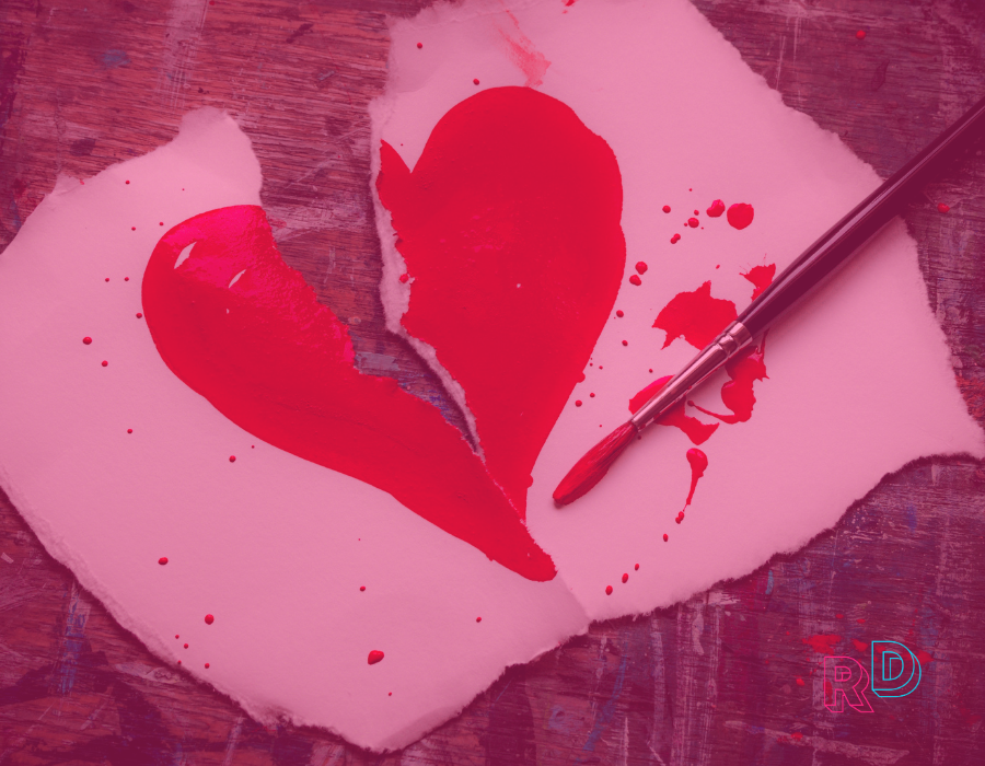 Red painted heart on torn paper