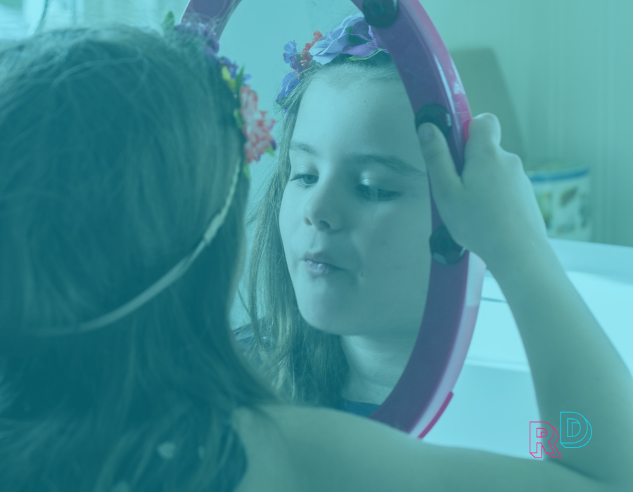 Little girl with flower crown looking in her mirror