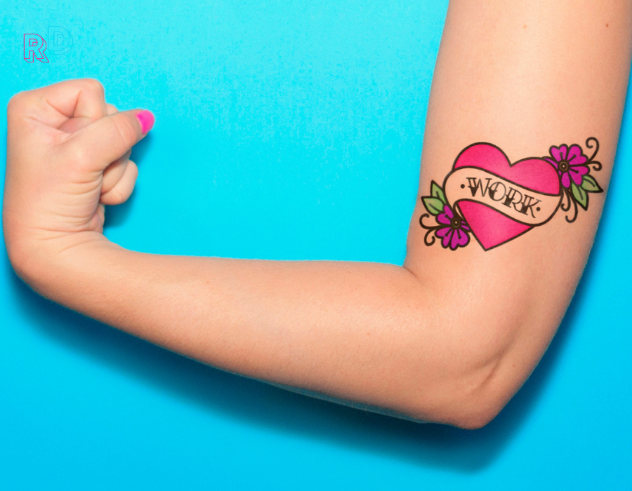 Woman's arm with work tattoo and blue background